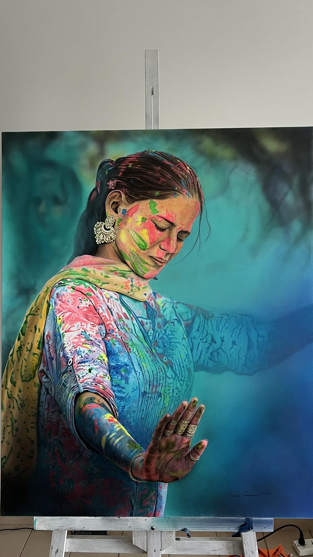 Pintura hiperrealista de una mujer cubierta de polvos de colores del festival Holi