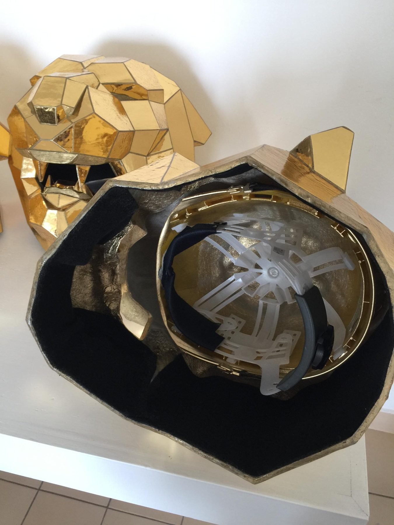 Escultura facetada de felino con acabado de espejo dorado